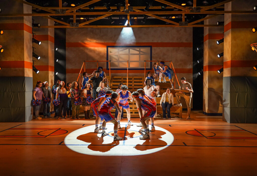 Lysistrata Jones — basketball team in tight back-light, short shadows, all attention focused down